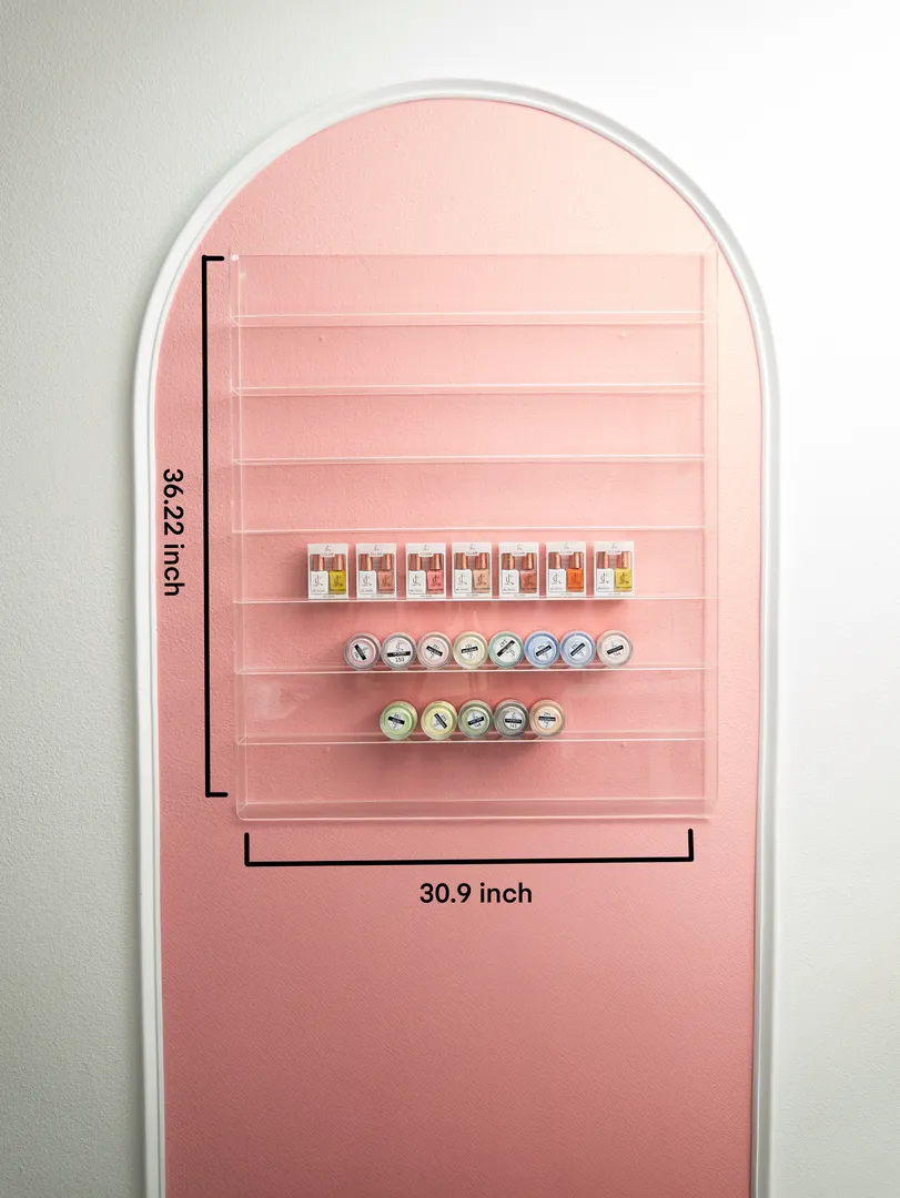 a clear nail wall rack hanging on a pink background wall